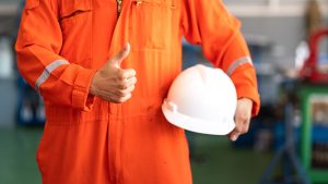 Man in orange coverall with a thumbs up
